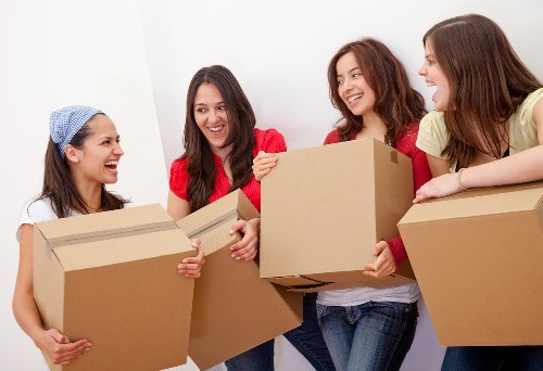 Professional movers handling furniture and boxes with protective equipment